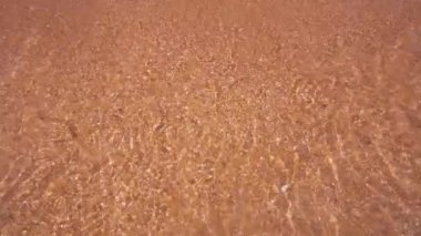 Sarı turuncu kumlu plaj. Şeffaf su dalgaları. Seyahat ve deniz tatili Yavaş çekim