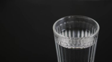 Siyah arka planda bir bardak su.