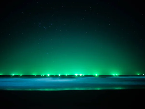Green light at horizon line over the sea, light from fishing boa