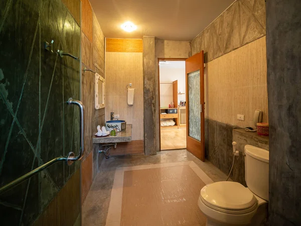 Інтер'єр ванної кімнати з туалетом в теплому світлі — стокове фото