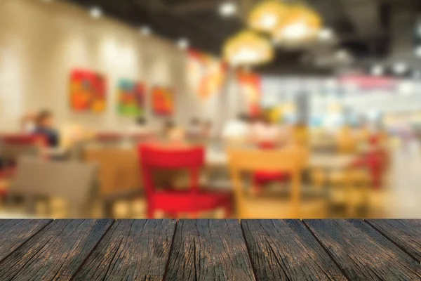 Дефокус внутри ресторана с деревянным столом на переднем плане . — стоковое фото