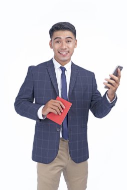 Kopya alanı ile beyaz arka plan izole pasaport ve akıllı telefon ile Asyalı genç yakışıklı iş adamı