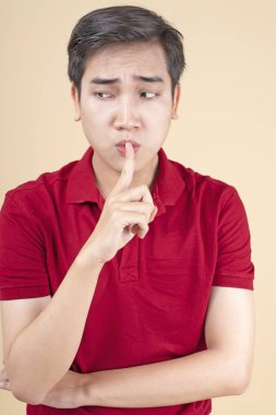 Asyalı genç yakışıklı ve neşeli erkek öğrenci el hareketi ile