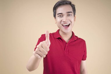 Asyalı genç yakışıklı ve neşeli erkek öğrenci el hareketi ile