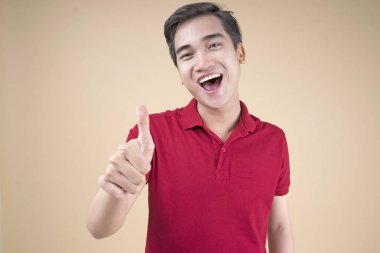 Asyalı genç yakışıklı ve neşeli erkek öğrenci el hareketi ile