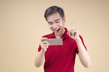 Asya genç yakışıklı ve neşeli erkek öğrenci el hareketi ve yüz ifadesi ile