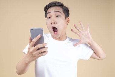 Asya genç yakışıklı ve neşeli erkek öğrenci el hareketi ve yüz ifadesi ile