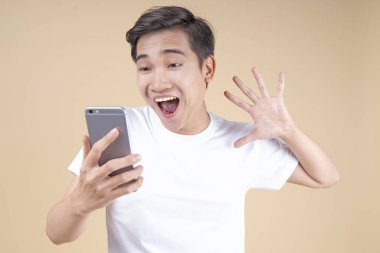 Asya genç yakışıklı ve neşeli erkek öğrenci el hareketi ve yüz ifadesi ile