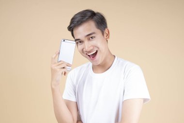 Asya genç yakışıklı ve neşeli erkek öğrenci el hareketi ve yüz ifadesi ile