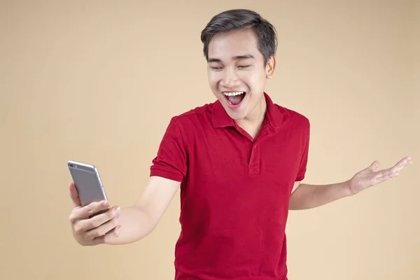 Asiático joven guapo y alegre estudiante masculino con gesto de mano y expresión de la cara — Foto de Stock