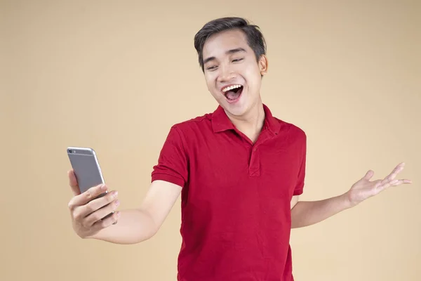 Asiático jovem bonito e alegre estudante masculino com gesto de mão e expressão facial — Fotografia de Stock