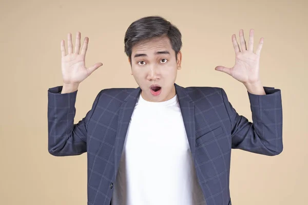Asiático joven guapo y alegre estudiante masculino con gesto de mano y expresión de la cara — Foto de Stock