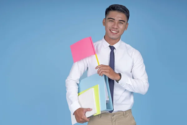 Asiático jovem estudante bonito com livro e bandeira em branco, no fundo azul claro — Fotografia de Stock