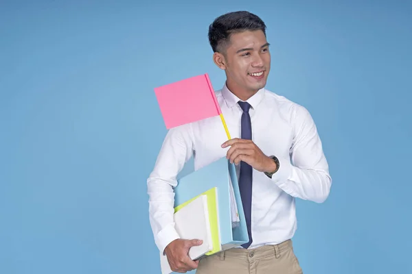 Asian young handsome student with book and blank flag, on light blue background — Stock Photo, Image