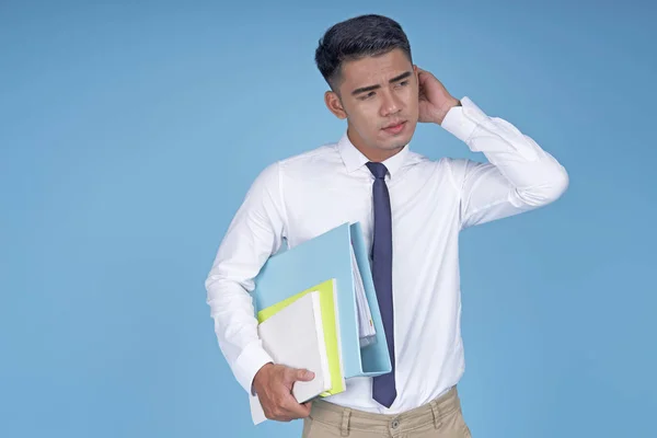 Asiatico giovane studente bello con libro e pensiero, su sfondo azzurro — Foto Stock