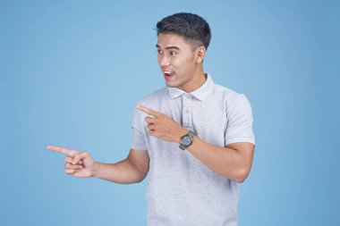 Açık mavi arka plan üzerinde el hareketi ile Asyalı genç yakışıklı adam