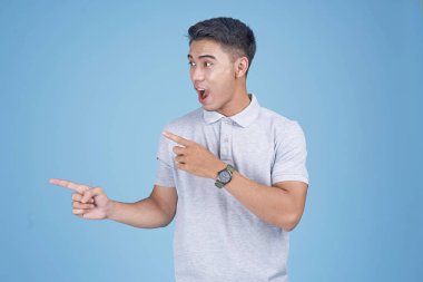 Açık mavi arka plan üzerinde el hareketi ile Asyalı genç yakışıklı adam