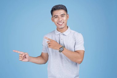 Açık mavi arka plan üzerinde el hareketi ile Asyalı genç yakışıklı adam