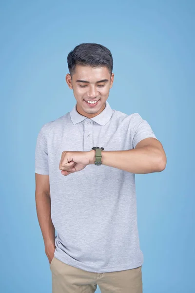 Asiático jovem estudante bonito com relógio inteligente no fundo azul claro — Fotografia de Stock