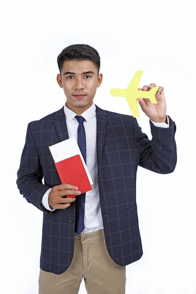 Азиатский привлекательный молодой бизнесмен с паспортом и самолетом — стоковое фото