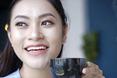 Asyalı oldukça çekici kadın akıllı kullanarak kahve dükkanında oturan