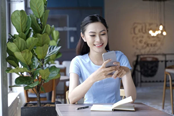 Asiático bastante atractiva mujer sentado en café tienda usando inteligente —  Fotos de Stock