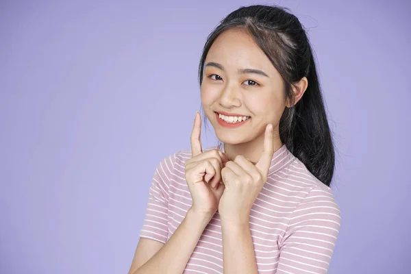 Aziatische jonge Teenage mooie vrolijke meisje met hand gebaar in roze shirt, op Violet achtergrond — Stockfoto