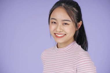 Pembe gömlek el hareketi ile Asyalı genç genç güzel neşeli kız, mor arka plan üzerinde