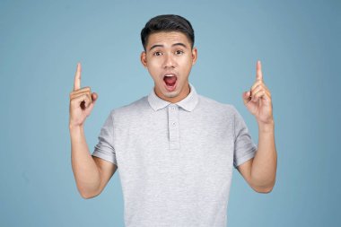 Yüz ifadesi ve el mavi arka plan üzerinde mesaj gösteren Asya genç yakışıklı çekici adam