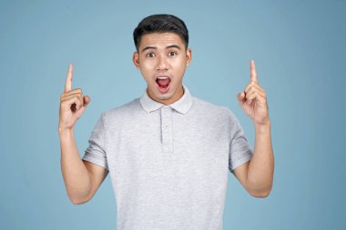 Yüz ifadesi ve el mavi arka plan üzerinde mesaj gösteren Asya genç yakışıklı çekici adam