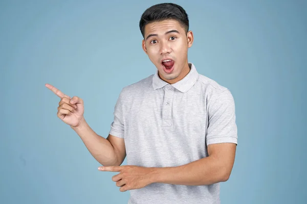 Asiatico giovane bello attraente uomo con faccia espressione e mano mostrando messaggio su sfondo blu — Foto Stock