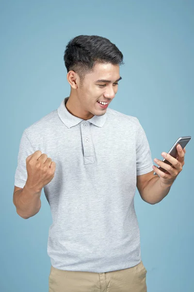 Asiatico giovane bello attraente uomo con smart phone su sfondo blu — Foto Stock