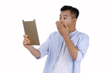 Asya yakışıklı genç adam yüz sürpriz e ile pad tablet tutan