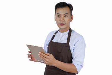 Asya yakışıklı genç garson tutan pad tablet, kahverengi renk bir