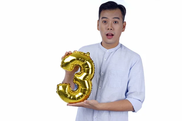 Ασίας όμορφος νέος άνδρας με κόμμα χρυσό μπαλόνι φύλλο, απομονωμένο — Φωτογραφία Αρχείου