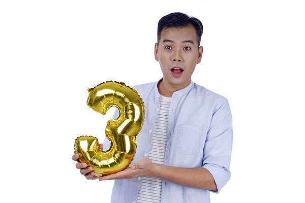 Asian handsome young man with party gold foil balloon, isolated — Stock Photo, Image