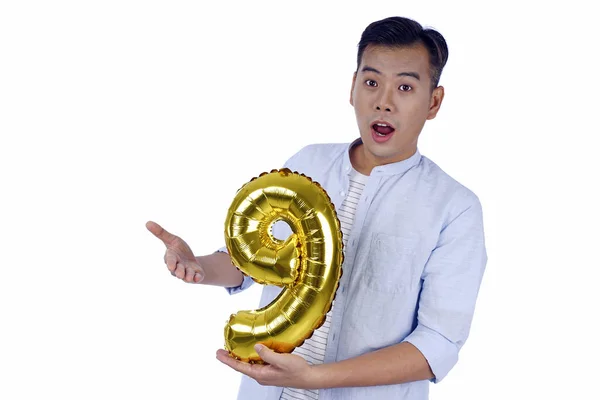 Asian handsome young man with party gold foil balloon, isolated — Stock Photo, Image