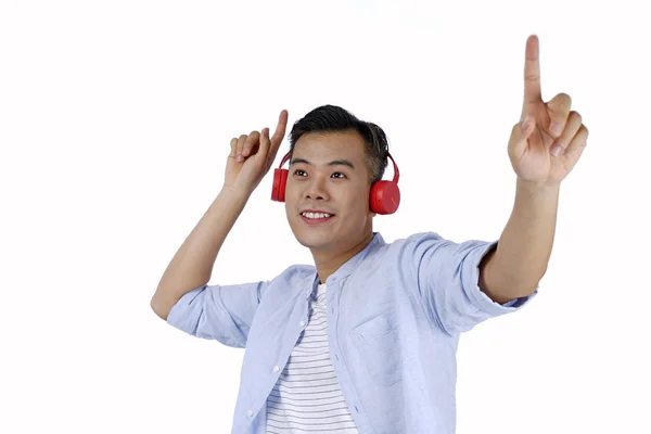 Asiático guapo joven escuchando música con auriculares rojos , — Foto de Stock