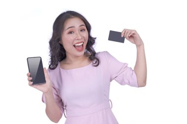 Zeki telefon ve kredi kartı alışverişi yapan, beyaz arka planda izole edilmiş Asyalı genç ve çekici güzel bir kadın.