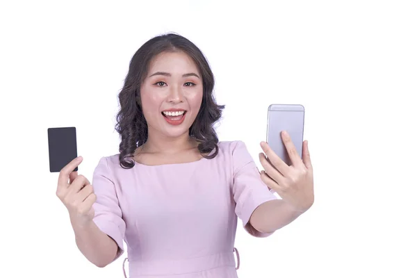 亚洲年轻貌美的漂亮女子，拥有智能手机和信用卡，在网上购物，与白人背景隔离 — 图库照片