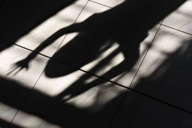Pencere kenarındaki küçük kızın gölgesi dehşet verici bir izlenim veriyor.