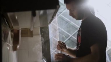 Adam Mutfakta taze yapılmış kahve fincan direksiyon