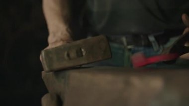 Smithy içinde bir çekiç ile çalışan demirci. 