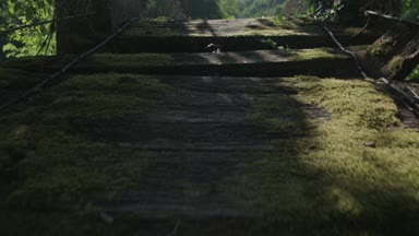 Adam eski asılı tahta köprüden karşıya. 