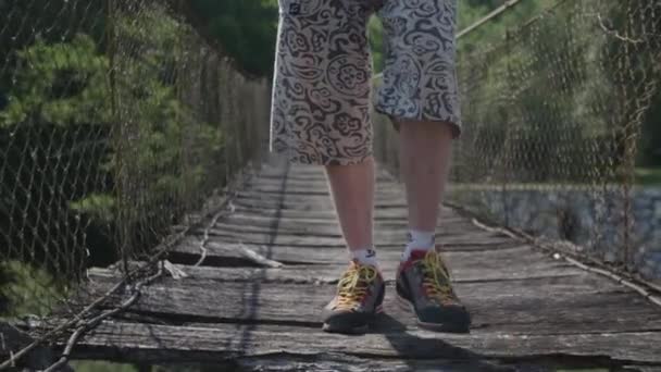 男は古い掛かる木の橋を渡る — ストック動画