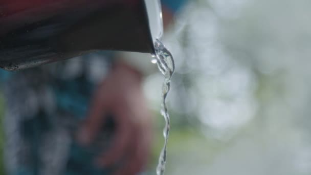 Man Het Gieten Van Water Uit Rode Pot — Stockvideo