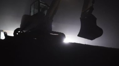 Hidrolik Ekskavatör kova ışık ile çevrili gece zamanında kullanarak. 