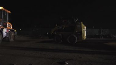  Skid yükleyici inşaat sitesinde yükleyicisi tarafından sürüş. 