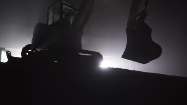 液压挖掘机使用桶在夜间时间 包围与光 — 图库视频影像