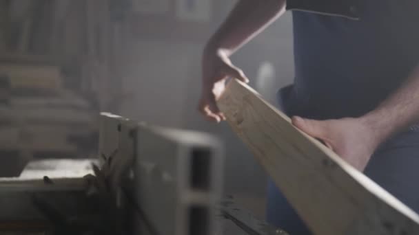 つなぎ服の男ワーク ショップで木製の梁を研磨しています — ストック動画